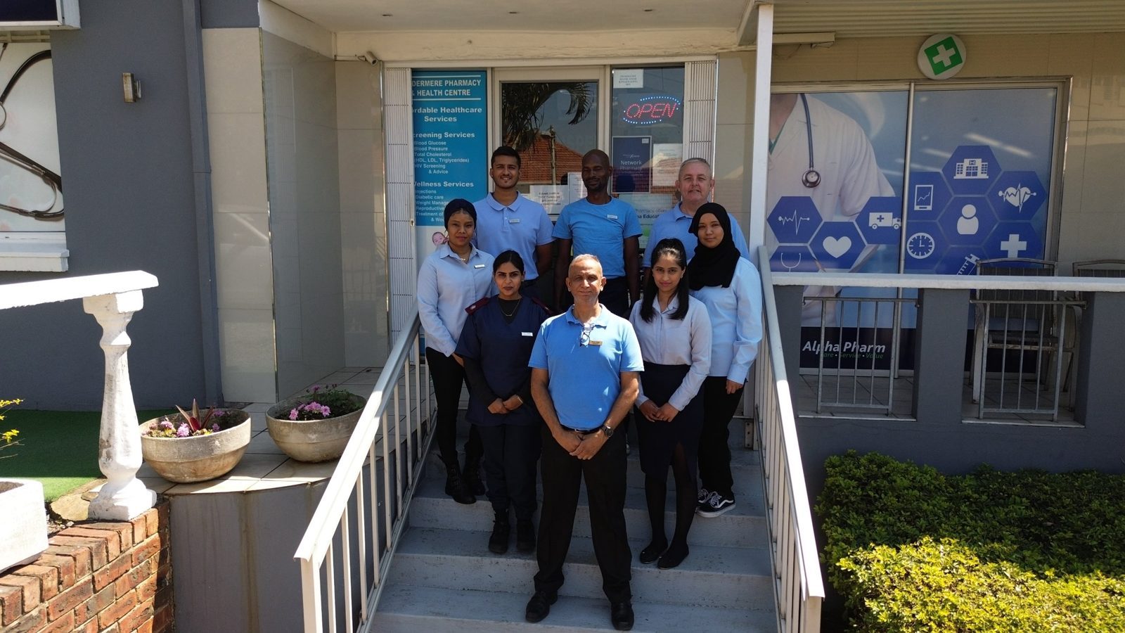 The Windermere Pharmacy and Health Centre team on the steps at the pharmacy entrance